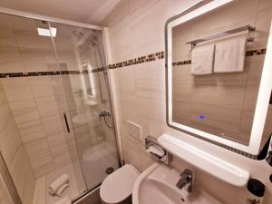 美因河畔法兰克福Hotel Frankfurt Messe的带水槽、淋浴和马桶的浴室
