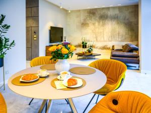 a living room with a table and chairs at Pietryna Apartments Luxury - Sauna , Jacuzzi , Bezpośrednio przy ul Piotrkowskiej in Łódź