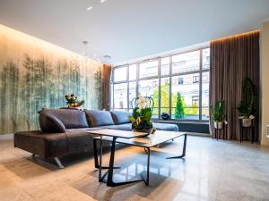 a living room with a couch and a table at Pietryna Apartments Luxury - Sauna , Jacuzzi , Bezpośrednio przy ul Piotrkowskiej in Łódź