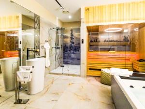 La salle de bains est pourvue d'une douche, d'une baignoire et d'un lavabo. dans l'établissement Pietryna Apartments Luxury - Sauna , Jacuzzi , Bezpośrednio przy ul Piotrkowskiej, à Łódź
