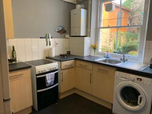 a kitchen with a washing machine and a sink at Flat Near Richmond Upon Thames in Richmond