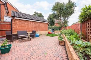 a backyard with a brick fence and a brick patio at The Lake Hub in Goodmayes