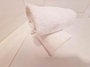 a white towel sitting on the floor in a bathroom at Hotel Frankfurt Messe in Frankfurt/Main