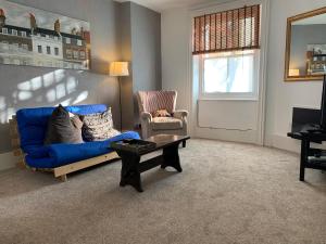 a living room with a blue couch and a table at Flat Near Richmond Upon Thames in Richmond