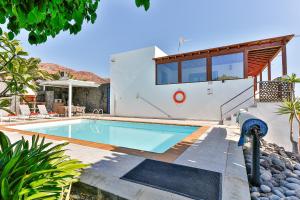 a villa with a swimming pool and a house at Sea Palms Lanzarote in Playa Blanca