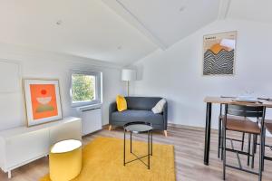 a living room with a table and a chair at Le Mimosa #Netflix #Centre-ville in Cognac +7 photos