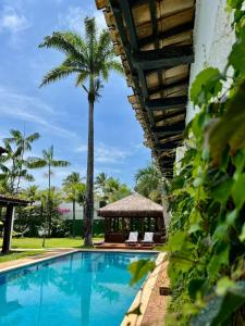uma piscina com um gazebo e palmeiras em Pousada Casa Paradiso Guarujá no Guarujá