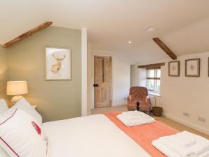 a bedroom with a white bed and a chair at The Lantern in Cheltenham