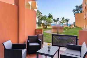 a patio with chairs and a table and a view of the ocean at Don Juan Beach Resort in Estepona