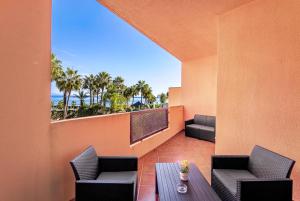 a balcony with a table and chairs and the ocean at Don Juan Beach Resort in Estepona