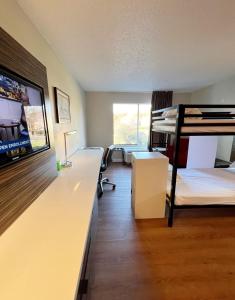 a room with two bunk beds and a desk at Bposhtels Charlotte in Charlotte