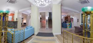 una hall con divano blu e lampadario a braccio di Artist hotel a Subotica