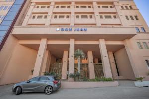 a car parked in front of a building at Don Juan Beach Resort in Estepona