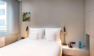 Un dormitorio con una cama blanca con almohadas blancas. en SANA Berlin Residence, en Berlín 44 fotos más
