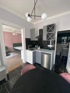 een keuken met roze kasten en een aanrecht bij Cozy modern space at the heart of the city in Debrecen