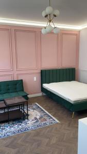 een slaapkamer met een bed, een bank en een tafel bij Cozy modern space at the heart of the city in Debrecen