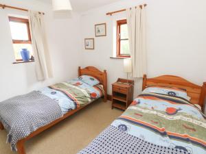 a bedroom with two beds and a table and windows at Banc Y Capel in Newport