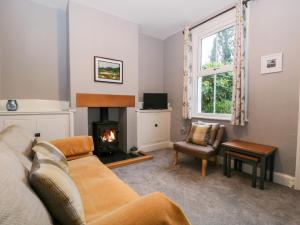 ein Wohnzimmer mit einem Sofa und einem Kamin in der Unterkunft 7 Railway Cottages in Ulverston