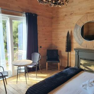 sypialnia z łóżkiem, stołem i lustrem w obiekcie BAITA MAORE luxury rooms & Spa w mieście Làconi