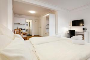 a white room with two beds and a kitchen at Haus Hoog Stean in Helgoland