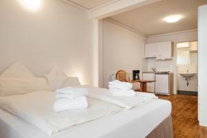 a white bed with white towels on top of it at Haus Hoog Stean in Helgoland