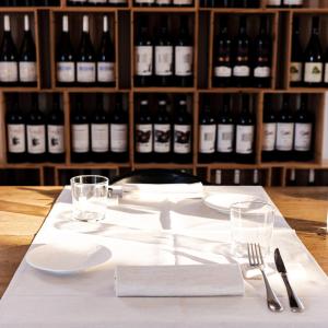 a table with white plates and wine bottles at Locanda Fontezoppa in Civitanova Alta