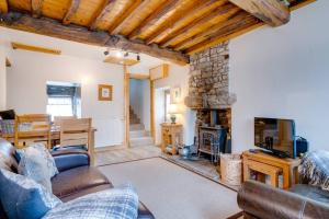 a living room with a couch and a fireplace at Penny Post Cottage in Warton