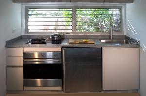 a kitchen with a stove and a sink at The Gatehouse. Cool bolthole. Walk to the Marina. in English Harbour Town