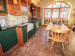 コールドストリームにあるCarriage Houseのキッチン(緑のキャビネット、テーブル、椅子付)