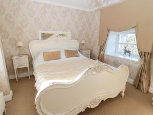 a white bed in a room with a window at Carriage House in Coldstream