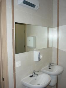 a bathroom with two sinks and a mirror at Pensión-Albergue Puente Ribeira in Sarria