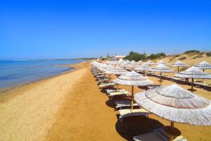- une rangée de parasols et de chaises sur une plage dans l'établissement Villetta Granelli, à Granelli