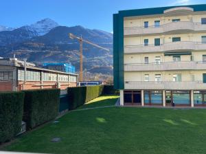 a building with a green lawn in front of it at Apartamento da Jenny in Aosta