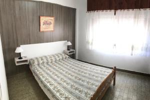 1 dormitorio con cama y ventana en Alquileres Bosero en Las Toninas