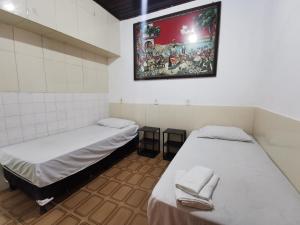 a room with two beds and a painting on the wall at Sos Hostel in Camaçari