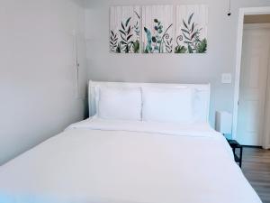 a white bed in a bedroom with a painting on the wall at Private Duplex Near BWI/Easy Access to I95 in Linthicum Heights