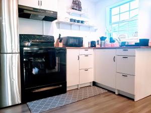 a kitchen with a black stove and white cabinets at Private Duplex Near BWI/Easy Access to I95 in Linthicum Heights