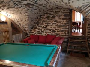 einen Billardtisch in einem Zimmer mit einer Steinmauer in der Unterkunft Les gîtes du Mistouflon in Planay