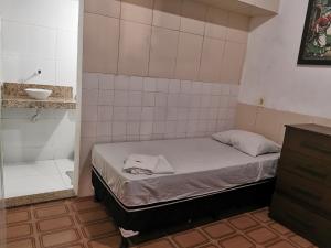 a small bedroom with a bed and a sink at Sos Hostel in Camaçari
