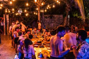 Un groupe de personnes assises aux tables d'une fête dans l'établissement Che Holbox Hostel & Bar Adults Only, à Holbox