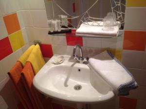 a white sink in a bathroom with colorful tiles at Familie Quellhorst in Leiden