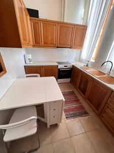 eine Küche mit Holzschränken und einer weißen Arbeitsplatte in der Unterkunft Abeliona Guesthouse in Ambeliona