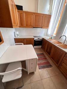 a kitchen with wooden cabinets and a white counter top at Abeliona Guesthouse in Ambeliona