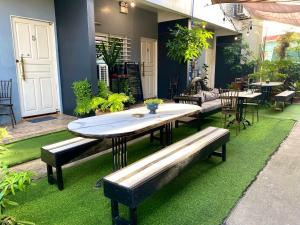 a patio with a table and benches on grass at CoG BnB Lubao -100 Mbps WiFi in Lubao