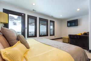 a bedroom with a bed and a couch and windows at 601 Deer Valley Drive in Park City