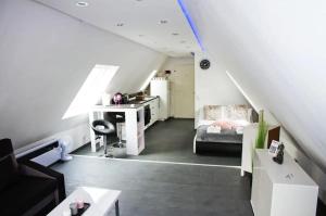 a living room with a staircase with a couch and a desk at Dachgeschoss-Apartment mit Küche & kostenloser Parkplatz in Dortmund