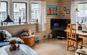 a living room with a table and a television at Awesome Home In Laukvik With Kitchen in Laukvik