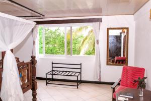 a room with a window and a bench and a mirror at Kahama Hotel Mombasa in Bamburi