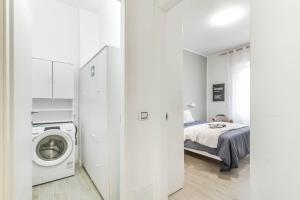 a white room with a bed and a washing machine at Casaballi Milano MM3 Trilocale in Milan