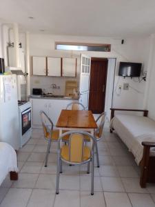 1 dormitorio y cocina con mesa y sillas. en Leticia y Fabián en Gualeguaychú
